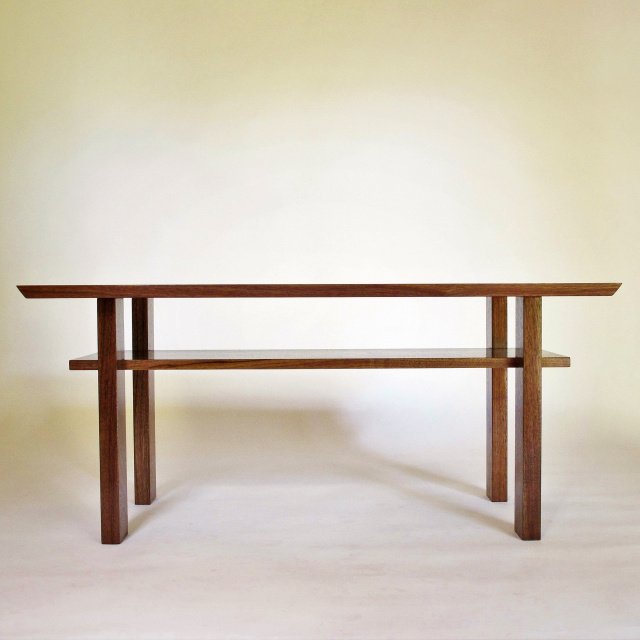 A narrow wood coffee table for small living rooms- pictured in solid walnut this handmade coffee table has a shelf for storage