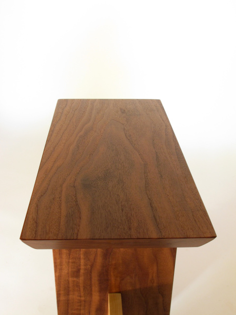The dark walnut wood wraps up and over the small entry seat
