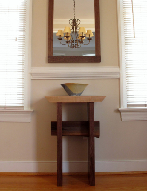 A small accent table in the dining room, a minimalist side table in tiger maple and walnut